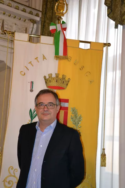 Il sindaco Marco Gallo davanti al gonfalone della Città con la medaglia d'argento a valore civile conferita per la strage di Ceretto