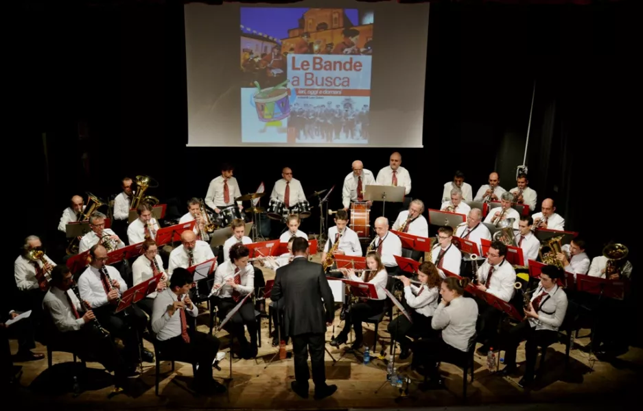 Il Concerto del Complesso bandistico musicale di Castelletto di Busca. Sullo sfondo la copertina del libro