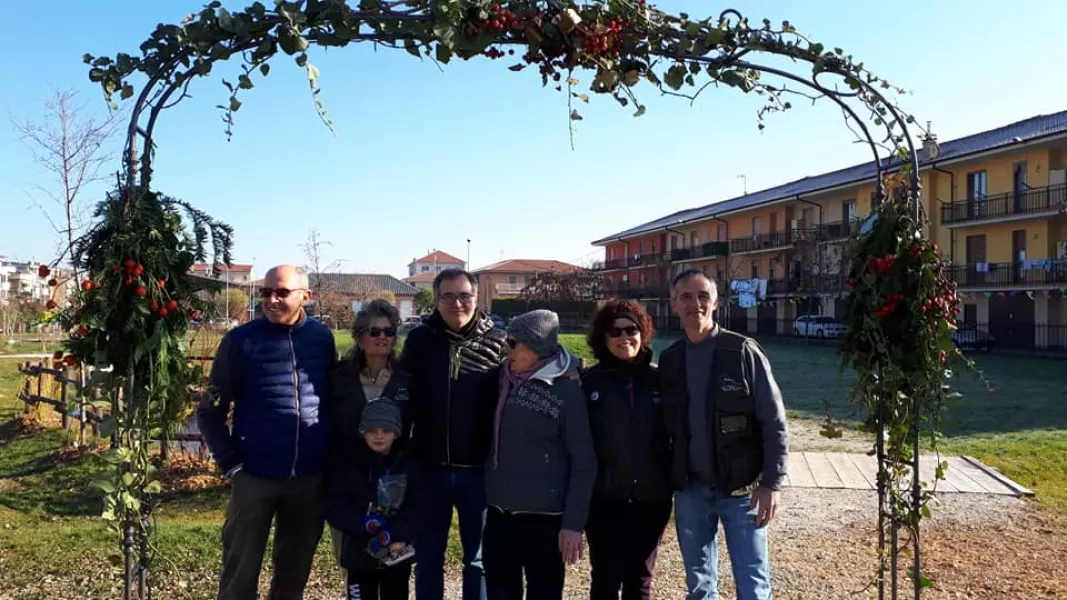 Il sindaco, Marco Gallo, con alcuni dei volontari di Busca & Verde al lavoro nel Giardino dell'infinito sotto il nuovo arco in ferro battuto dell'ingresso