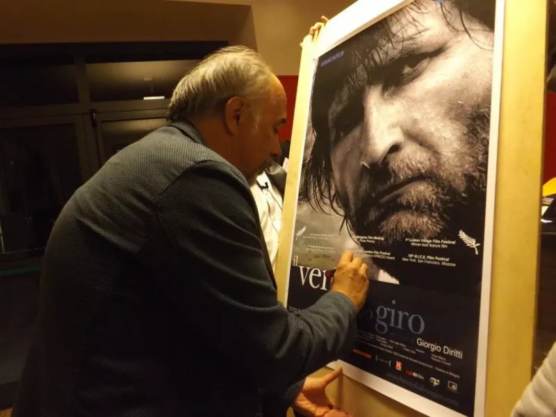 Il regista Giorgio Diritti al cinema Lux di Busca nello scorso settembre autografa il manifesto del suo  film Il vento fa il suo giro, che ha ispirato il titolo della nuova stagione teatrale della Residenza