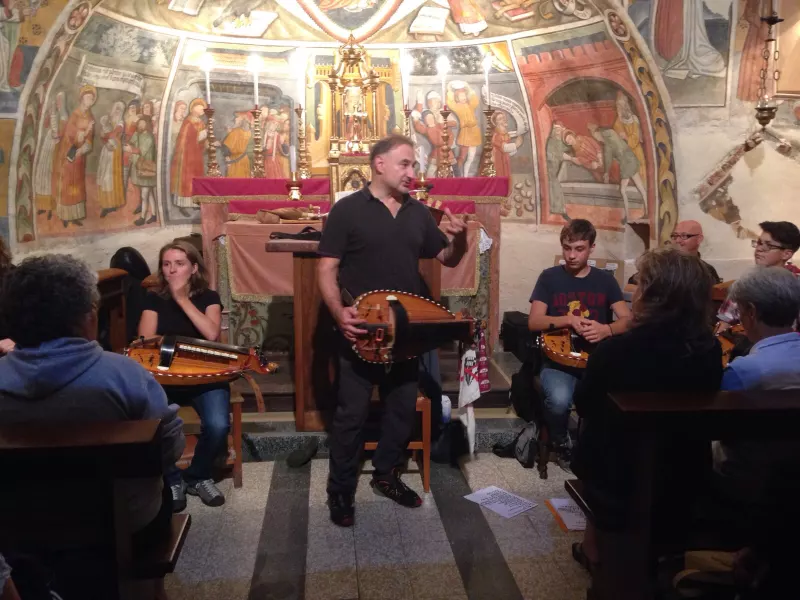 Sergio Berardo direttore della Grande Orchestra Occitana  e il su ensemble di ghironde nella cappella di Santo Stefano sulla collina omonima