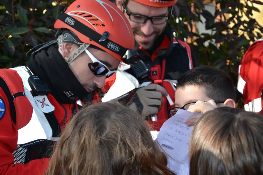 Richiesta di autografi. Gli alunni in fila per riceverli dai volontari del Soccorso ambienti impervi