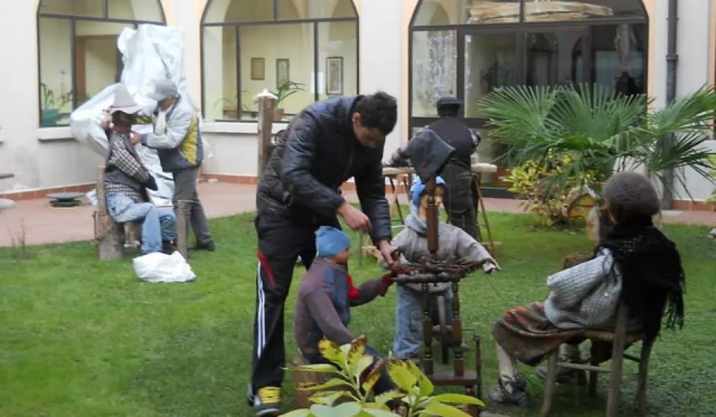 I volontari allestiscono il presepe nel giardino della casa di riposo