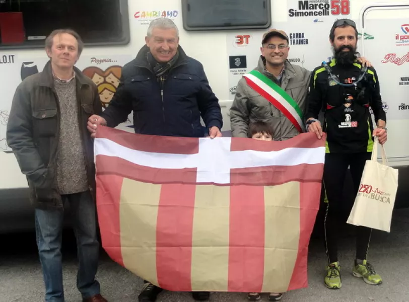 Marco Chinazzo con la bandiera di Busca, accolto dal sindaco, Luca Gosso, dal presidente di Busca Eventi, Gianpiero Marino, e dall'organizzatore del gemellaggio con Moglia,  Alberto Arioli 