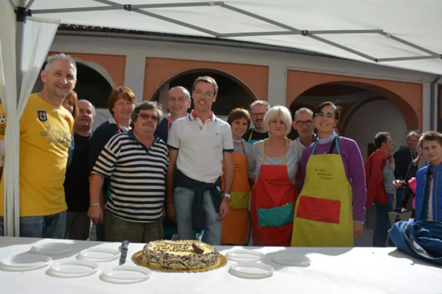 Un momento della festa con, al centro, don Marco Casalis e i volontari Amici dell'oratorio