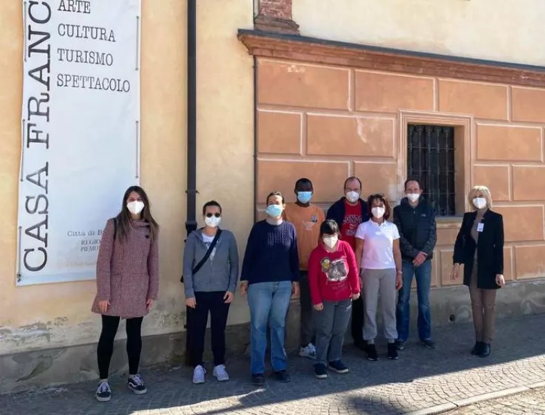 Da sinistra, la assessora ai Servizi sociali Beatrice Aimar con alcuni ospiti e operatori di Casamica davanti a Casa Francotto, centro culturale comunale che in questo periodo di pandemia mette a disposizione del cerntro diurno  parte dei locali