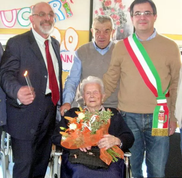 La signora Agostina nel giorno del suo centesimo compleanno, alle sue spalle il figlio Eugenio, alla sua destra il presidentede dell'ente Ospedale civile, Tommaso Alfieri, alla sua sinistra il vice-sindaco, Marco Gallo