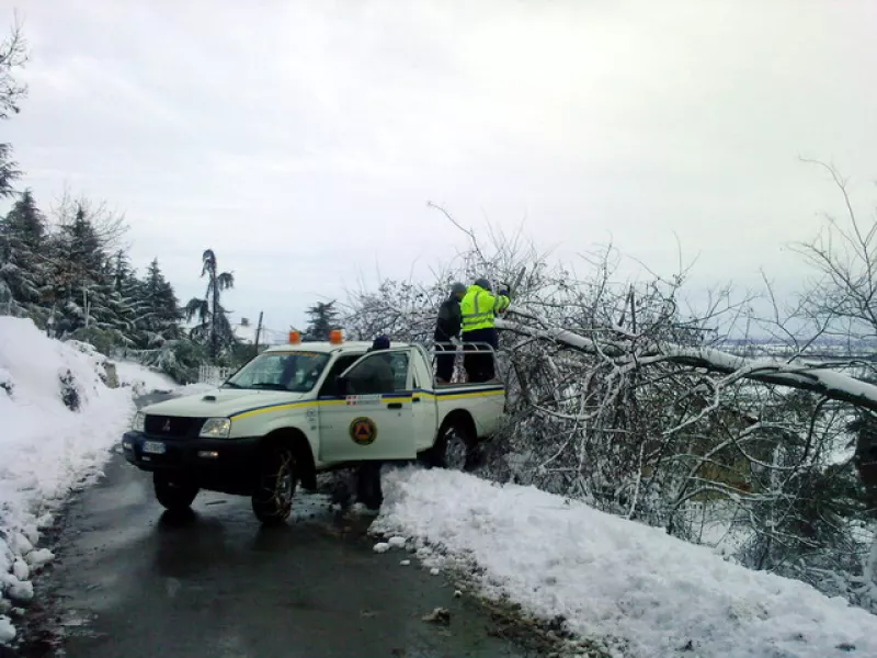 Volontari della Protezione civile comunale al lavoro lungo una strada di collina durante una nevicata dello scorso inverno