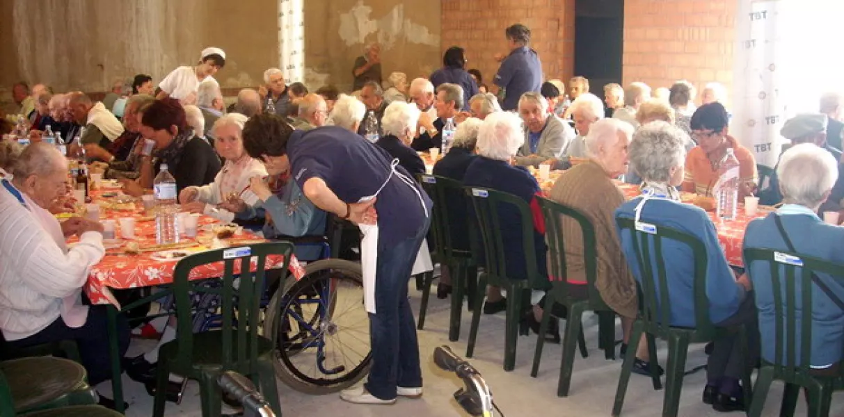 Tutti  a tavola in attesa del polenta: i volontari verificano se ci sia bisogno di aiuto