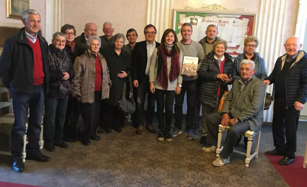 Al centro, i due ospiti argentini con il libro ricevuto in omaggio, vicino al sindaco e insieme ai loro parenti buschesi