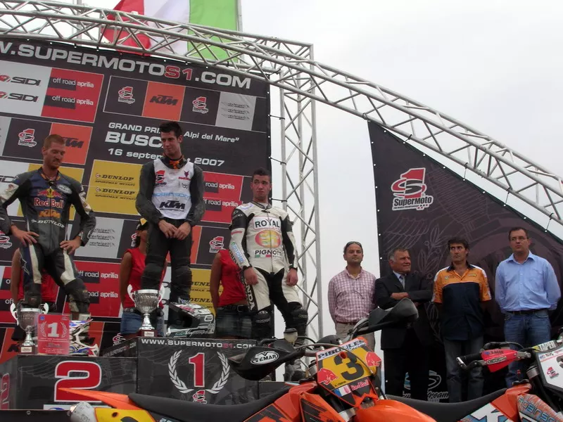 Sul podio del circuito di Busca i vincitori della categoria S1 del Gran premio mondiale di supermoto Alpi del Mare 2007; sullo sfonfo il sindaco di Busca, Luca Gosso, e l'assessore comunale al Turismo, Gianmichele Cismondi, che hanno premiato il primo ed il secondo classificato; inseme con loro, l'assessore provinciale al Turismo, Angelo Rosso, e l'assessore comunale al Commercio, Marco Gallo