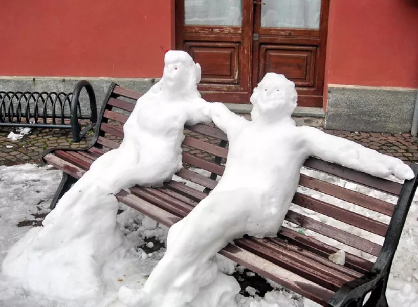 La coppia di neve seduta su una panchina in piazza della Rossa