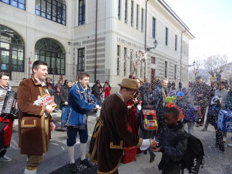 Coriandoli e caramelle di fronte alle scuole