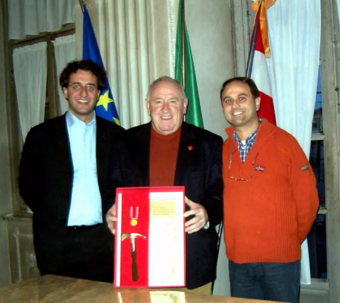 Dario Fusta, con la medaglia d'oro e la picozza d'argento, fra l'assessore al Volontariato Giuseppe Delfino e il sindaco Luca Gosso