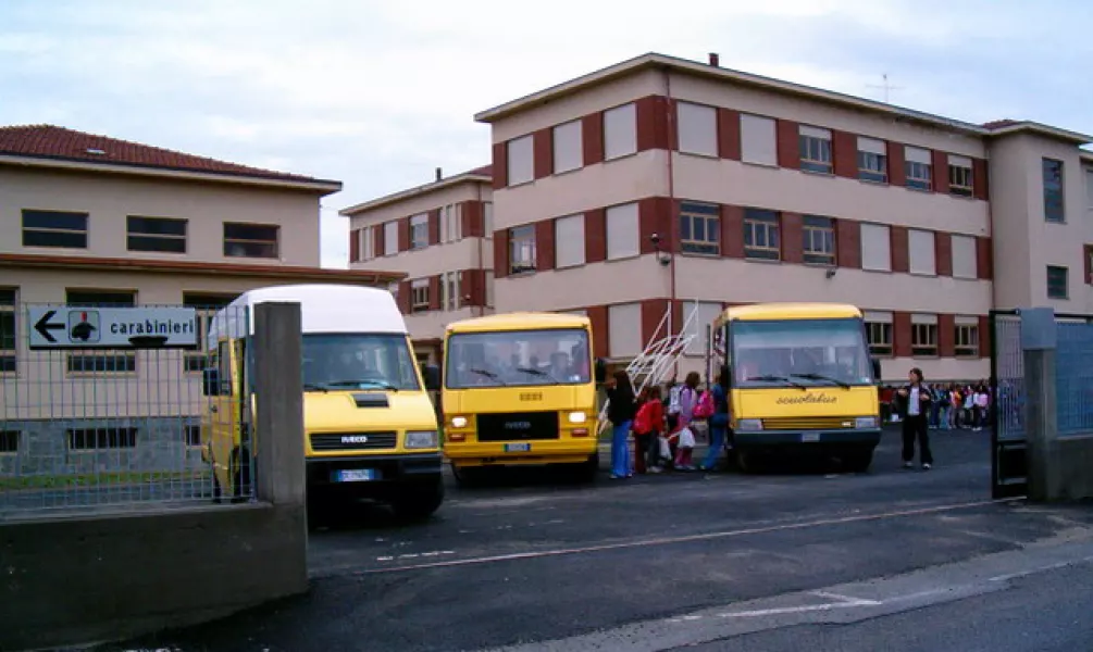 Gli studenti accedono ai bus all'interno del cortile delle scuole medie