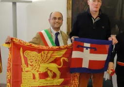 Luca Gosso, promotore del Movimento dei Sindaci del Piemonte, e Antonio Guadagnini, creatore del Movimento dei Sindaci del Veneto e ispiratore della propoate di legge, si scambiano i vessilli delle due Regioni