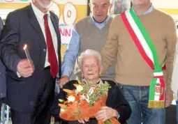 La signora Agostina nel giorno del suo centesimo compleanno, alle sue spalle il figlio Eugenio, alla sua destra il presidentede dell'ente Ospedale civile, Tommaso Alfieri, alla sua sinistra il vice-sindaco, Marco Gallo