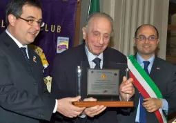 Giuseppe Fassino riceve il premio dal presidente del Lions Busca e Valli, Marco Gallo, con loro il sindaco di Busca, Luca Gosso