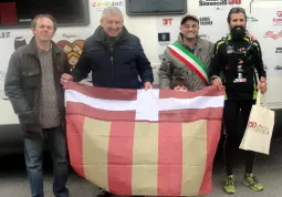 Marco Chinazzo con la bandiera di Busca, accolto dal sindaco, Luca Gosso, dal presidente di Busca Eventi, Gianpiero Marino, e dall'organizzatore del gemellaggio con Moglia,  Alberto Arioli 