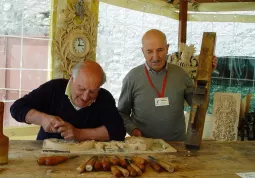 Un intagliatore del legno dimostra la sua arte nel laboratorio in mostra