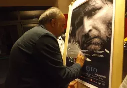 Il regista Giorgio Diritti autografa il manifesto del suo  film nell'atrio del cinema Lux