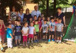 Il sindaco di Caldarola Luca Giuseppetti con i bambini e le insegnanti vicino allo scivolo acquistato con i contributi arrivati da Busca