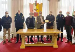 Ettore Nicolino riceve la targa dal sindaco, insieme con i componenti della giunta e il coordinatore della Protezione civile comunale