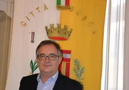 Il sindaco Marco Gallo davanti al gonfalone della Città con la medaglia d'argento a valore civile conferita per la strage di Ceretto