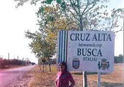 L'insegnante argentina di fianco al cartello di entrata in Cruz Alta con gli stemmi delle due cittÃ  gemellate. Trinidad Cardini ha scritto una poesia su Busca, giocando con il significato, in spagnolo, del verbo 'buscar', ossia 'cercare'...