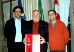 Dario Fusta, con la medaglia d'oro e la picozza d'argento, fra l'assessore al Volontariato Giuseppe Delfino e il sindaco Luca Gosso