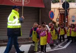 Il volontario della Protezione civile guida il piedibus e spiega a i bambini come ci si comporta per strada....