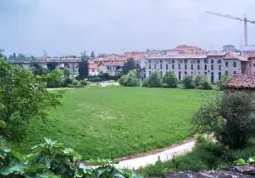 Il terreno che andrÃ  all'asta, sullo sfondo il ponte sul Maira e la gru della ristrutturazione del palazzo ex filanda